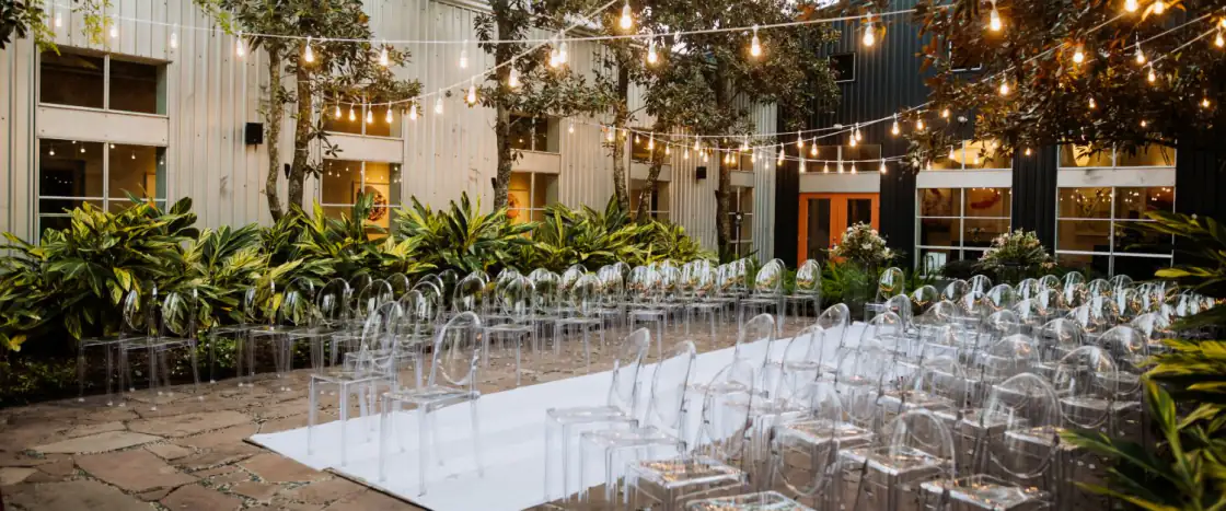 Outdoor event venue courtyard with string lights and ceremony seating